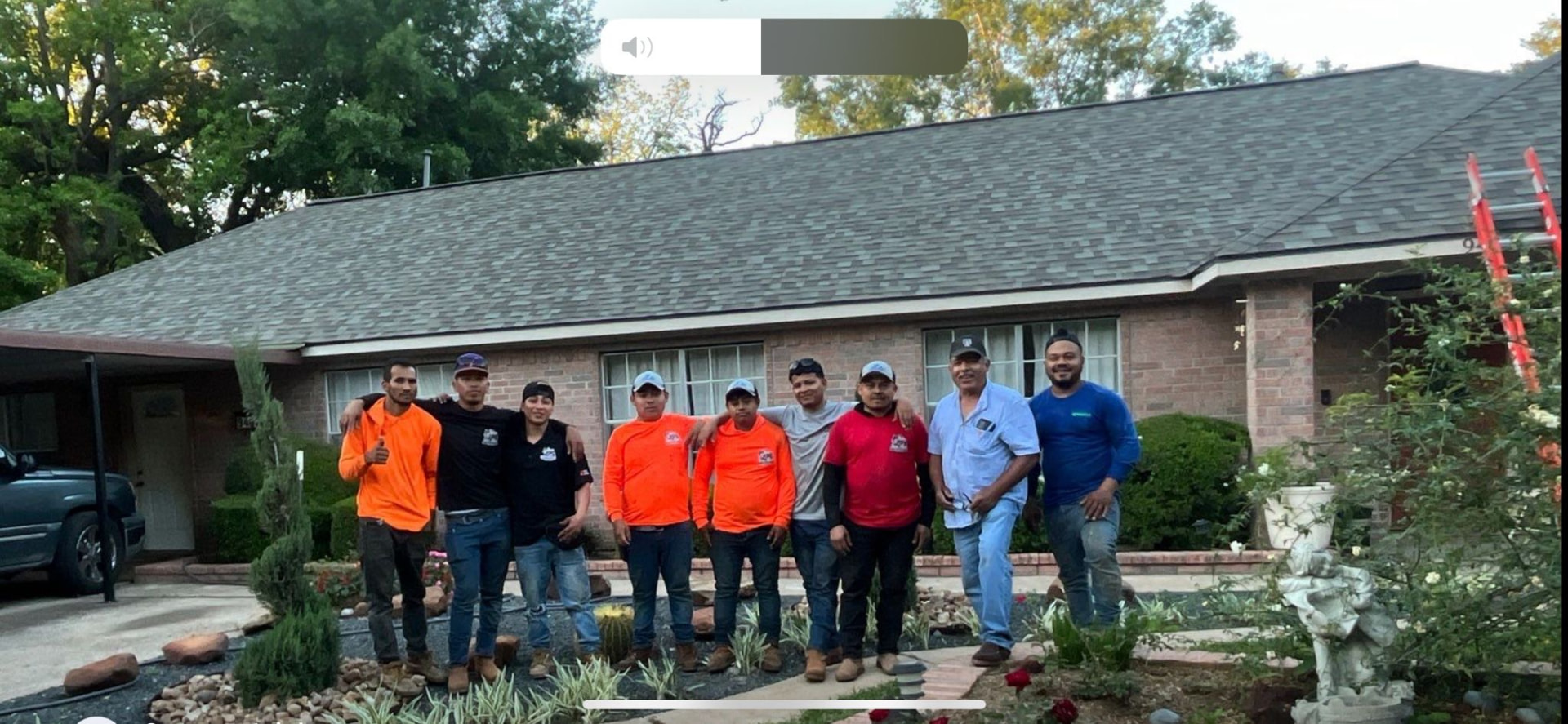 Roofing team standing in front of a finished architectural shingle roof on a Houston-area brick home