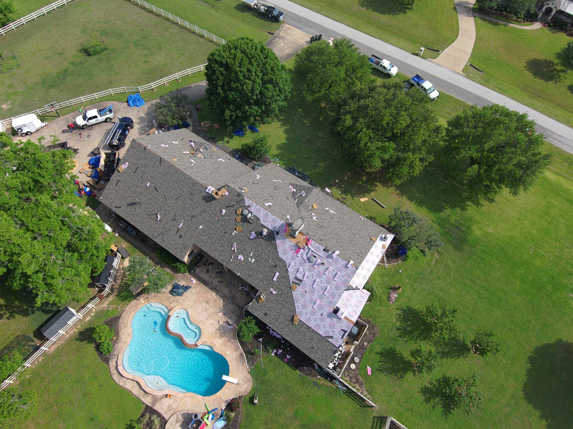 Aerial drone photo of a shingle roof replacement in progress on an acreage property